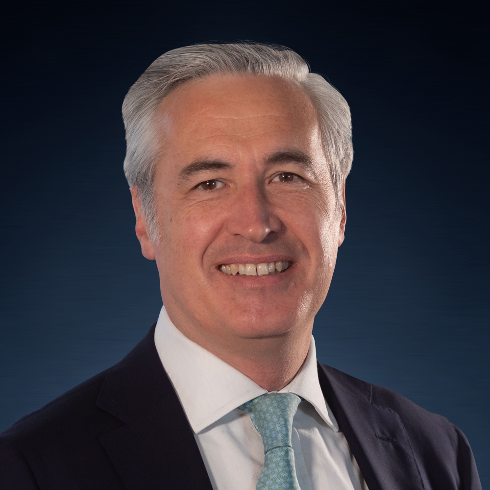 A person in a suit smilingDescription automatically generated with low confidence