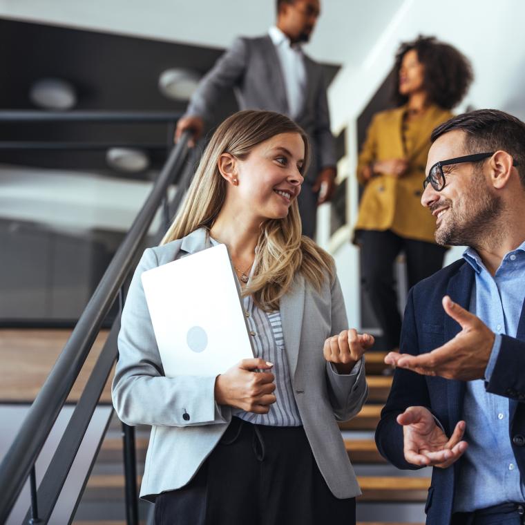 Colleagues Engaging in a Pleasant Discussion on Office Staircase