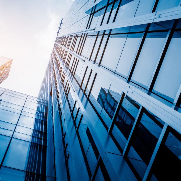 Modern office building against blue sky, blue tone