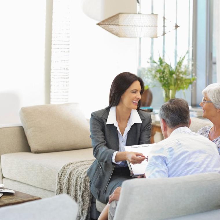 Financial advisor talking to couple on sofa