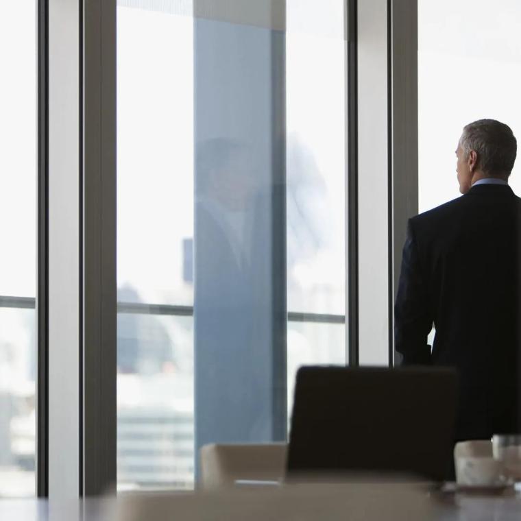 man staring out of window