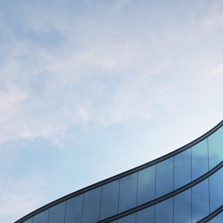 Perspective of high rise building and dark steel window system with clouds reflected on the glass.Business concept of future architecture,lookup to the angle of the building corner.