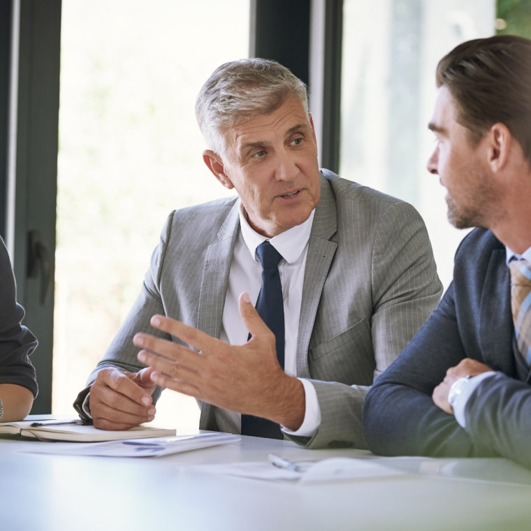 Meeting, collaboration and planning with a manager and team in the boardroom for a coaching seminar. Teamwork, strategy and workshop with a mature business man talking to his staff in the office