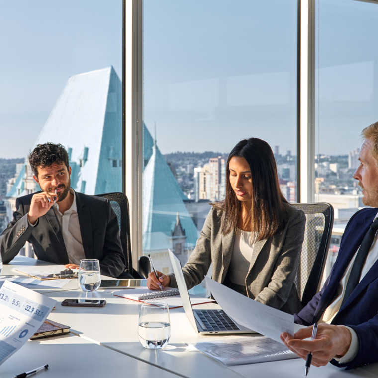 Busy international executives young team people working at board room table. Diverse professional employees group discussing marketing project strategy working together in office meeting room.