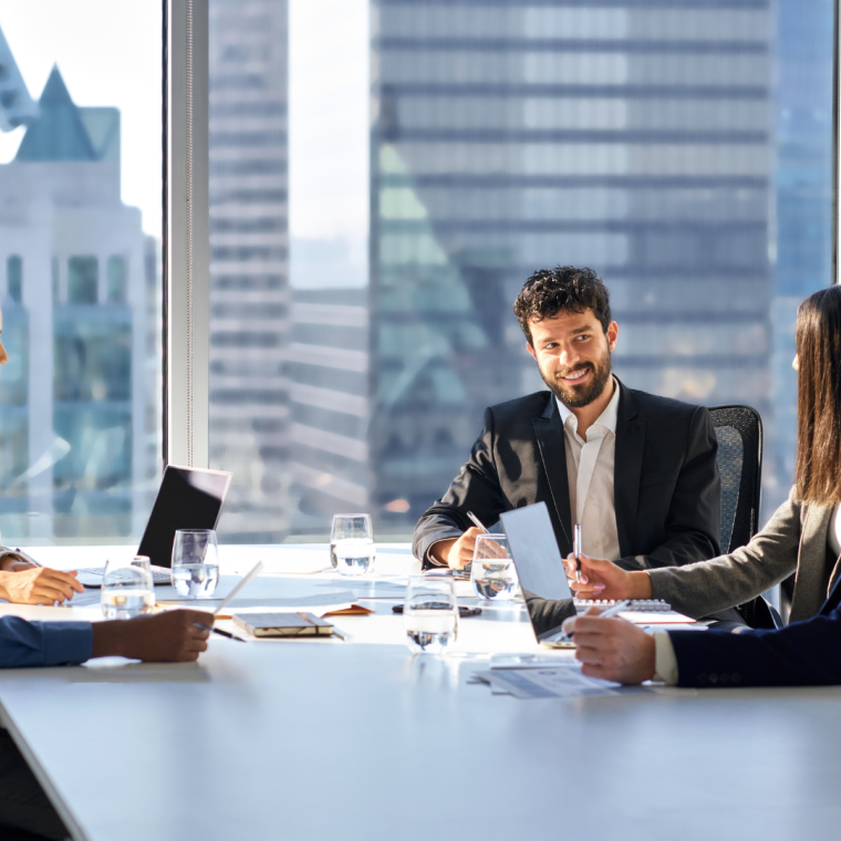 Happy international multiethnic professional business team, diverse executive colleagues people discussing financial project working together in office at group meeting table in corporate board room.