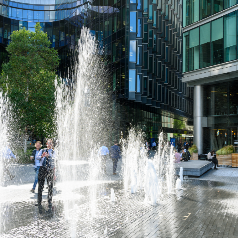 People in London, walking through between the water jets and fountains 