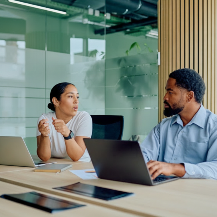 Two diverse business colleagues discussing ideas at an office table. They are collaborating and working together on a project 