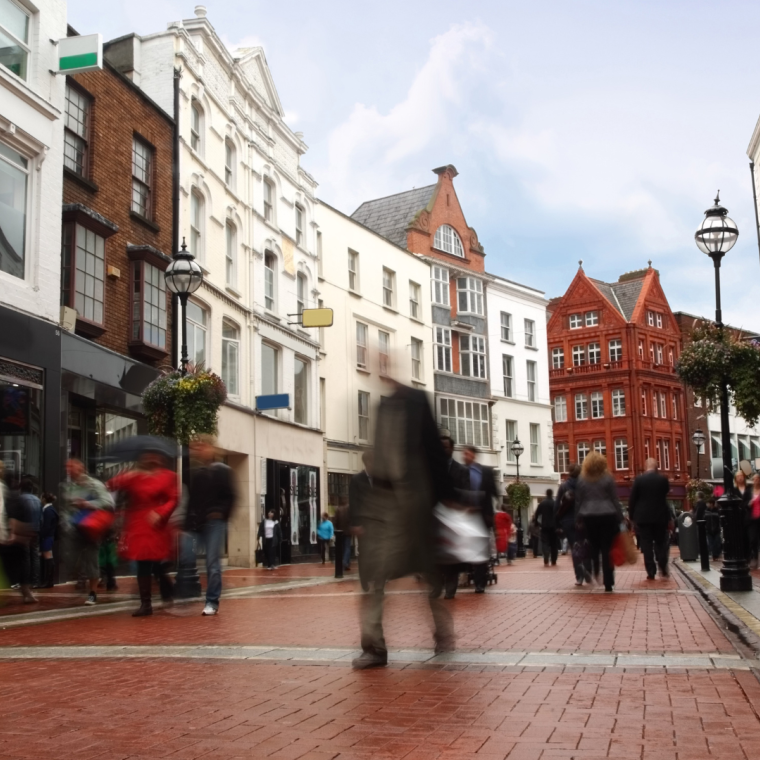 people quickly going on small, narrow street in cloudy weather 
