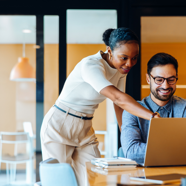 Business professionals discussing a project while using a laptop in an office