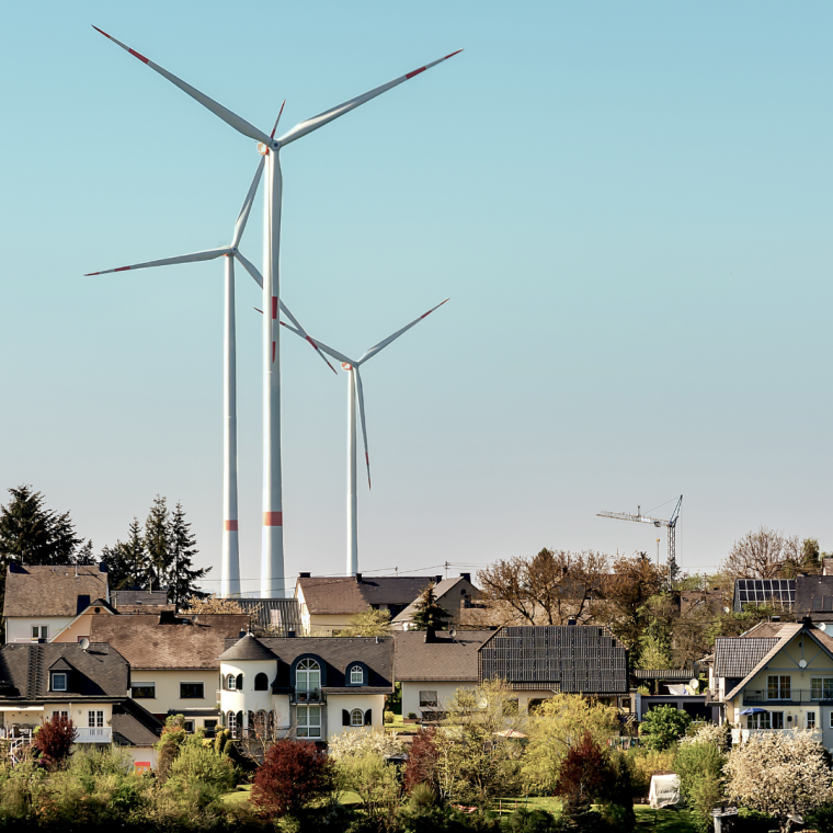 Wind turbines or a group of wind power converters in Germany against the backdrop of a sunny spring landscape on the road from Mörsdorf to the famous "Geierlay" suspension bridge.