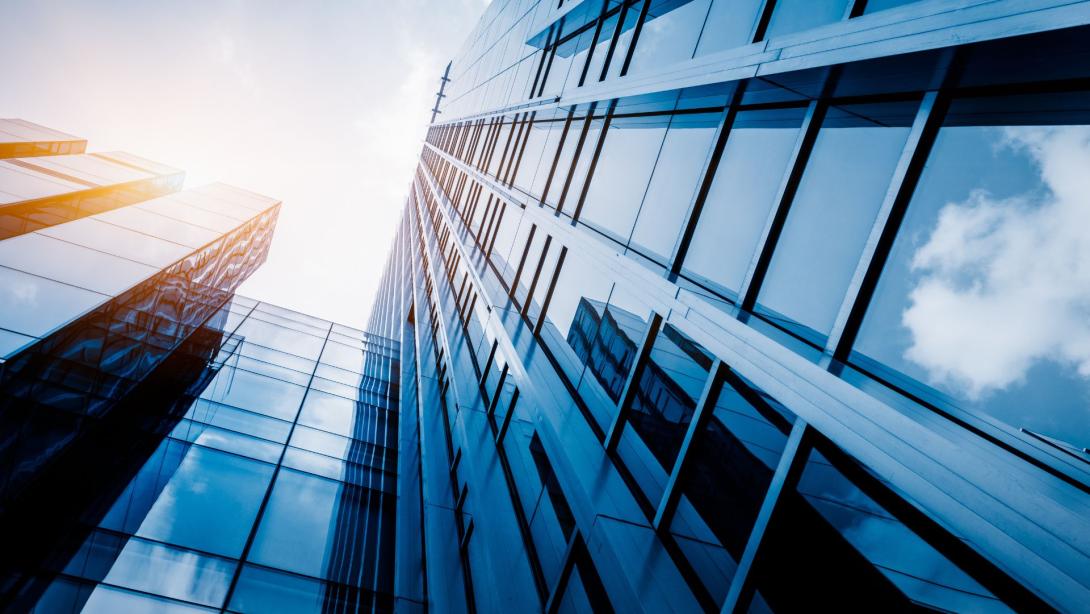 Modern office building against blue sky, blue tone