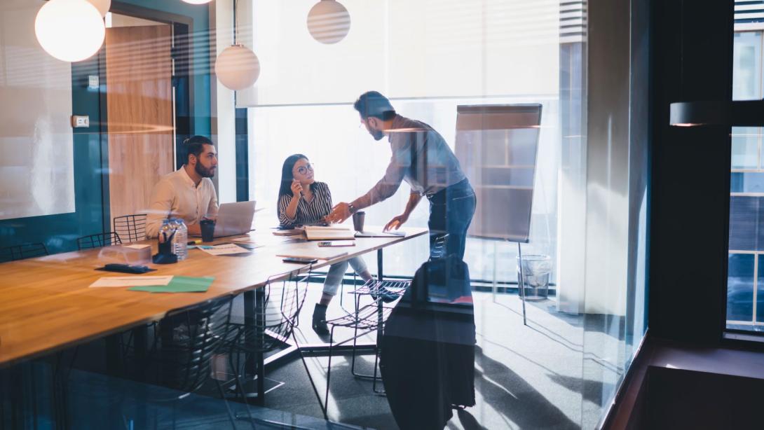 Coworkers in boardroom alongside third party loan agent