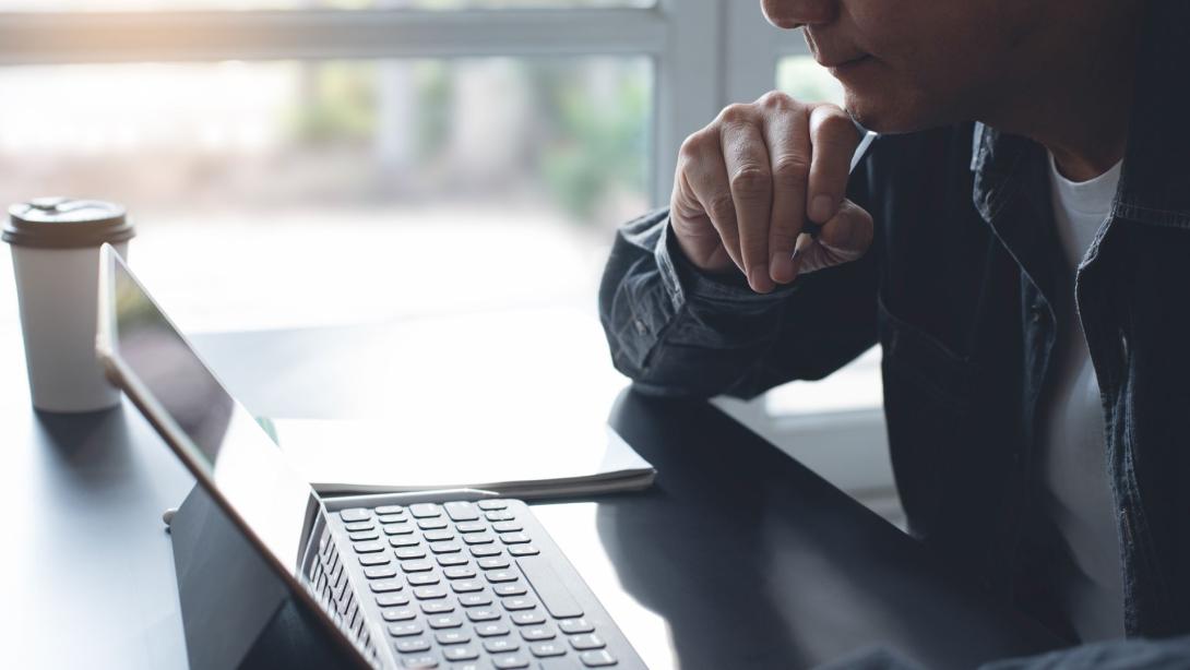 Pensive business man thinking while serious working on laptop computer from home office
