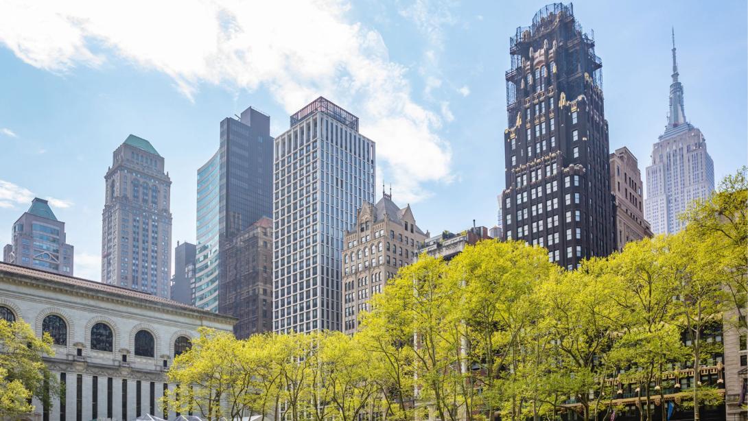 Bryant park, New York, Manhattan. High buildings view from below against blue sky background, sunny day in spring