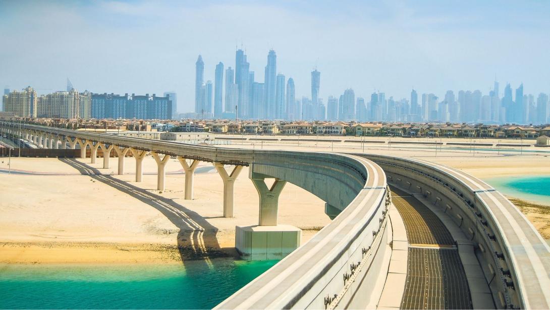 Monorail bridge on a man-made island Palm Jumeirah looking at Dubai Skyline
