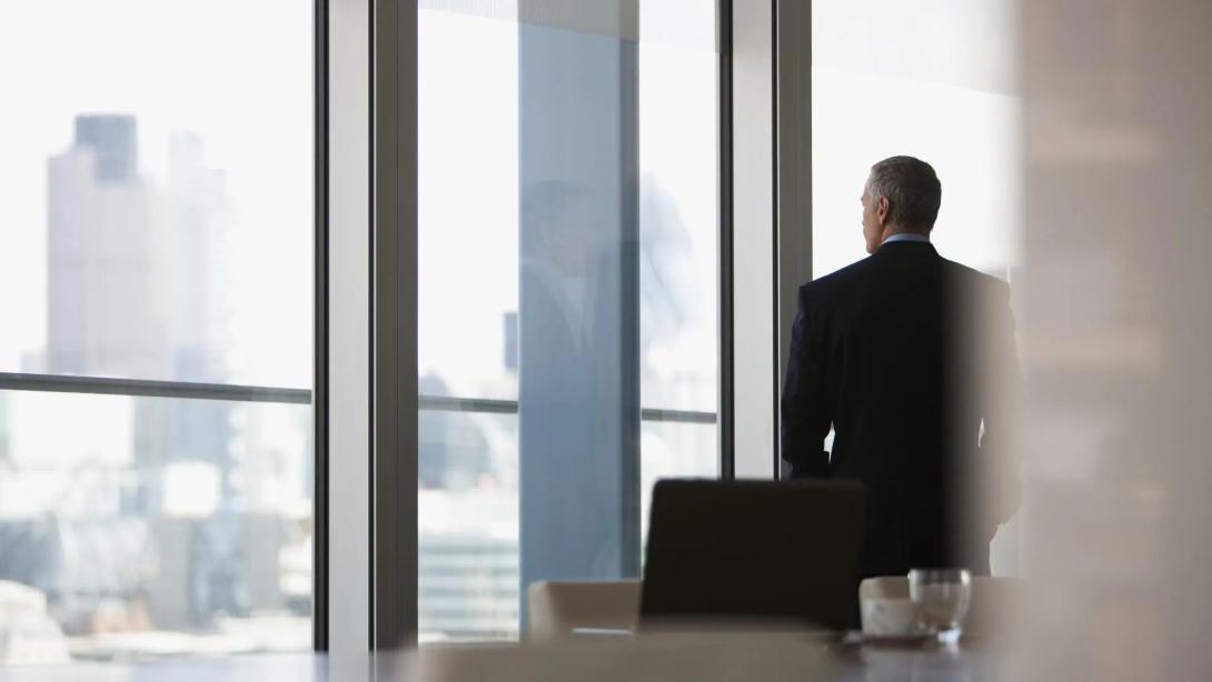 man staring out of window