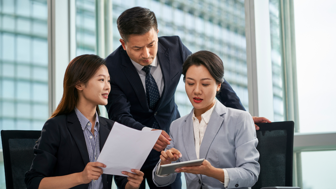 team of asian corporate executives discussing business in office