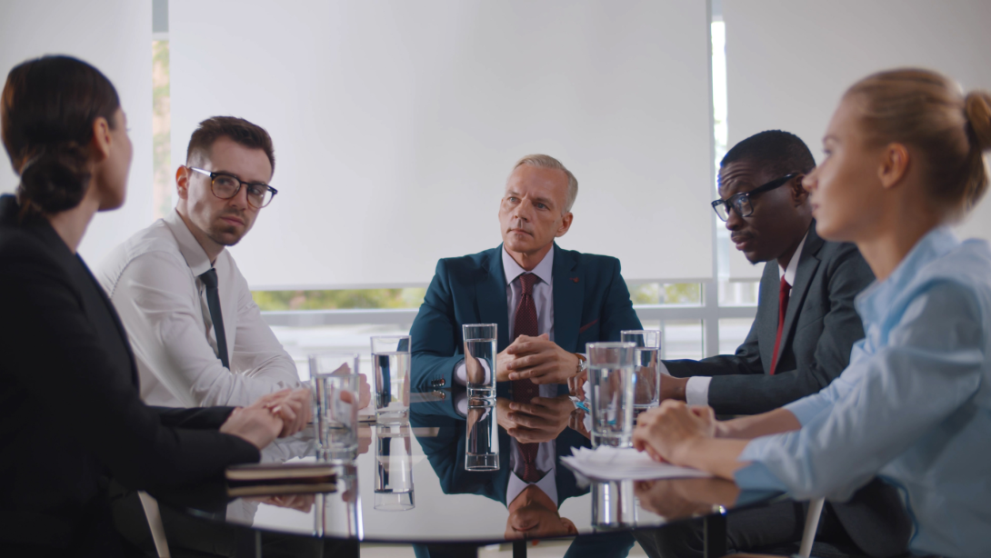 Business leader holding corporate meeting with team in boardroom 