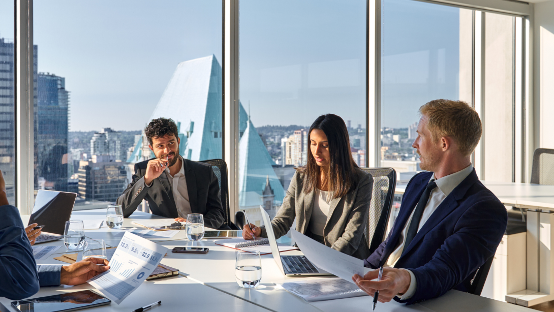 Busy international executives young team people working at board room table. Diverse professional employees group discussing marketing project strategy working together in office meeting room.
