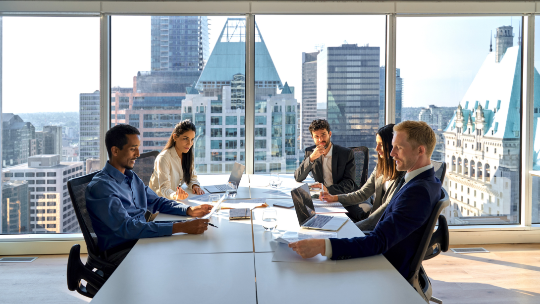 Multiethnic professional busy employees and executives board team people at group meeting discussing work results managing company project plan working together in modern board room office.