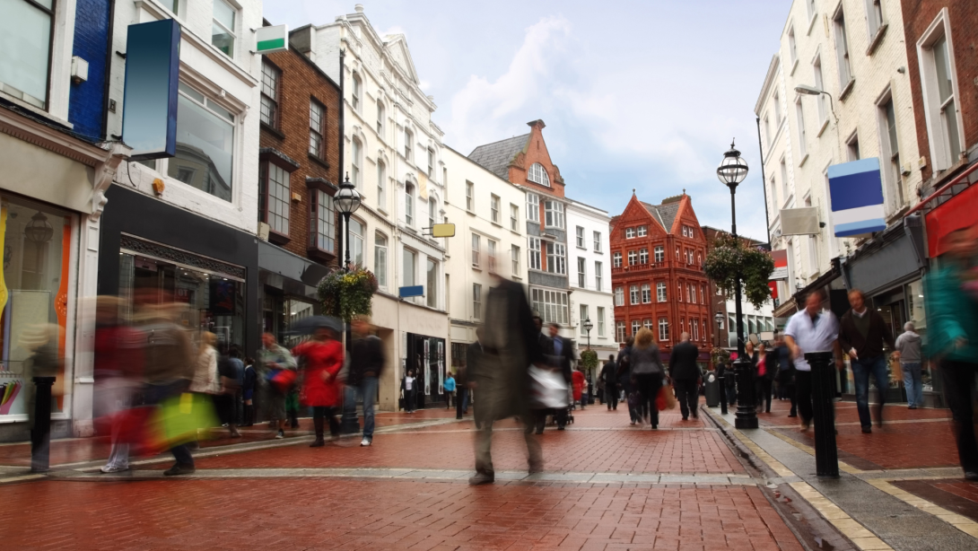 people quickly going on small, narrow street in cloudy weather 