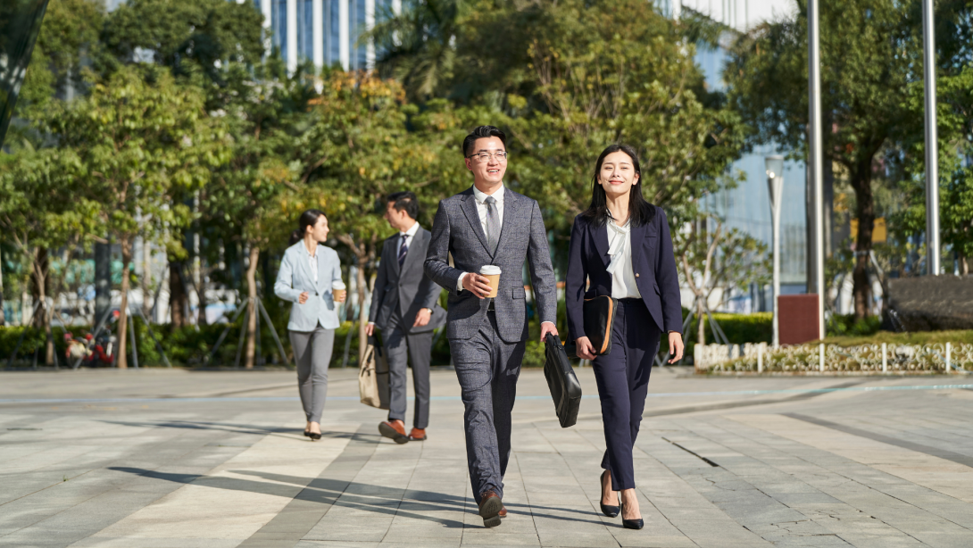 young asian businesspeople walking on street 