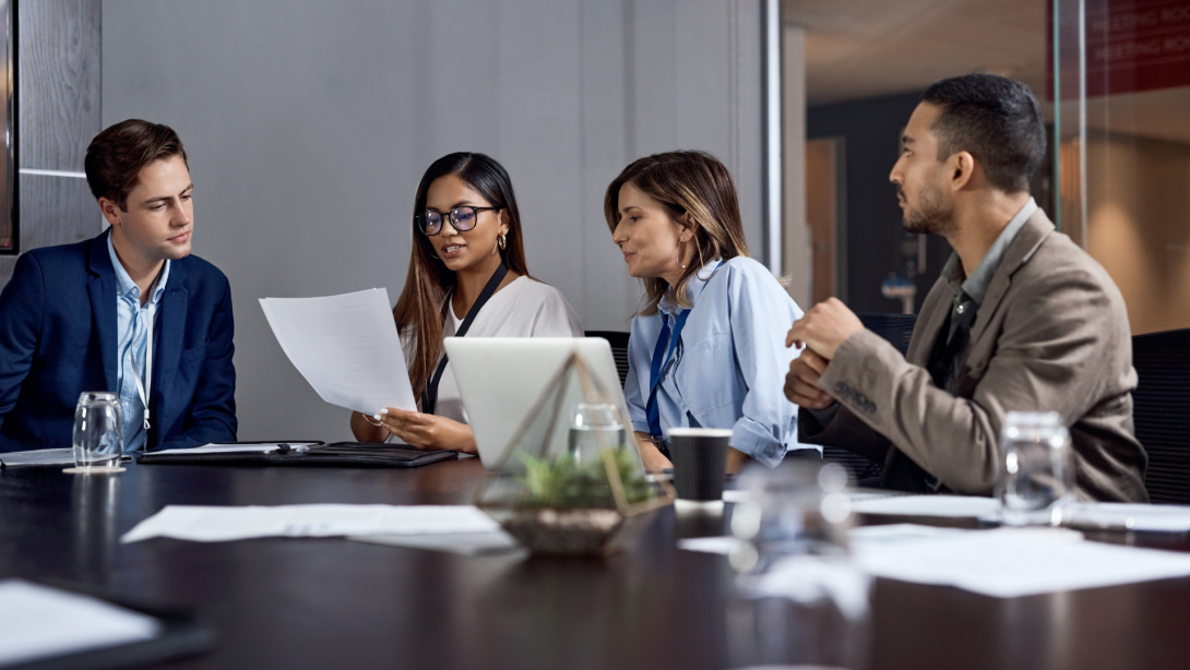 Business, team or meeting discussion with document for merger plan, integration review or valuation.